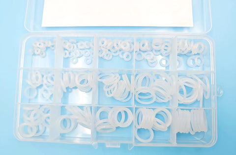 Front view of a clear plastic storage box containing 225 white silicone O-rings in various sizes.