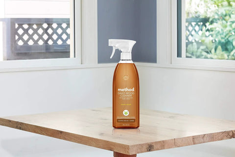 Almond Scent Daily Wood Cleaner For Wood Surfaces Cleans Dust And Grime From Tables Shelves Counters And Panels With A 28 Oz Spray Bottle Pack Of 8 Cruelty Free And People Tested on a wooden table.
