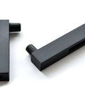 Close-up of two black iron track connectors from Ornate Cut Roller Black Iron Sliding Barn Hardware Kit For Single Door Hardware Only, Door Not Included 5 Foot Track With Wall Mount Supports Up To 270 Lbs Fits Doors Up To 30 Inches Wide And 1 3 8 To 1 3 4 Inches Rollers Stoppers Track Connectors.