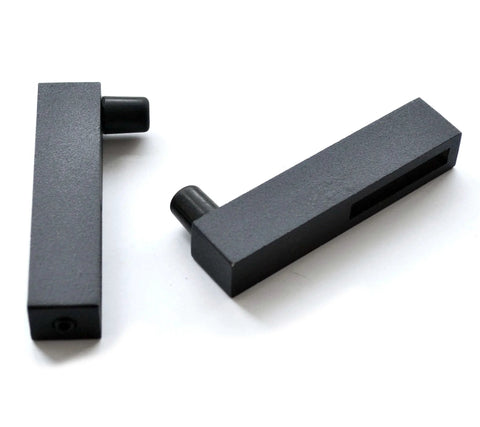 Close-up of two black metal stoppers from the Ornate Black Iron Sliding Barn Door Hardware Kit For Single Door With 5.5 Foot Track, Heavy Duty Build