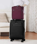 Person holding underseat carry on luggage with USB port 16 inch two wheel spinner bag on top of black suitcase.