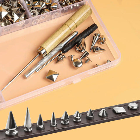 Close-up of Dope 550 Piece Punk Studs And Spikes Kit with conical studs, tools, and accessories on leather and in a box.
