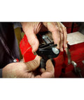 Powerbuilt Universal Thread Repair Tool, black metal, held by hands beside a red bench vise.