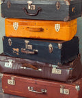 Stack of vintage suitcases with retro cabinet duckbilled toggle hasp and antique padlock kit highlighting classic old school vibe