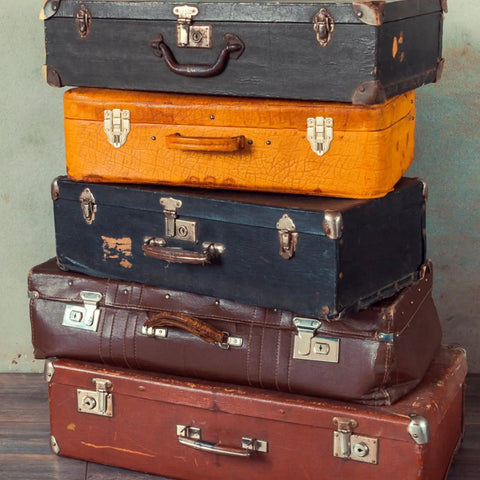 Stack of vintage suitcases with retro cabinet duckbilled toggle hasp and antique padlock kit highlighting classic old school vibe