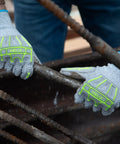 Impact Protection Safety Gloves With Polyurethane Palm Coating A4 Cut Level 13 Gauge Seamless Knit Touchscreen Compatible Helix 1074IMP Large Size Durable Grip For All Day Work, worn by a worker handling metal rods.