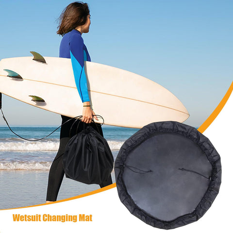 No Fuss Surf And Swim Changing Mat With Waterproof Sandproof Wetsuit Dry Bag shown by surfer on beach with surfboard