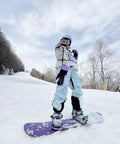 Person snowboarding in Womens Baggy Ski Bibs And Snowboard Pants Waterproof Windproof Insulated Overalls on a snowy slope.