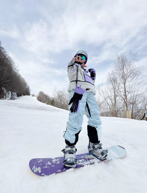 Person snowboarding in Womens Baggy Ski Bibs And Snowboard Pants Waterproof Windproof Insulated Overalls on a snowy slope.