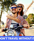 Couple riding a motorcycle on a sunny day with trees and buildings in the background.