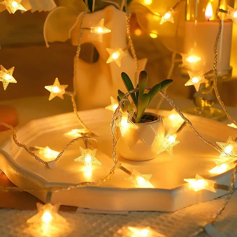 Warm White LED Star String Lights 10 Ft Battery Operated For Indoor Outdoor Decor draped over a small plant on a decorative tray