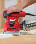 Person using 2.0 Amp 1/4 Sheet Palm Sander With Pressure Control, Clear Dust Canister, Micro Filtration, And Dust Sealed Switch