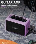 Compact 5W Guitar Amp for On the Go with Dual Speakers in Purple, showing headphone jack and control knobs on a patterned surface.