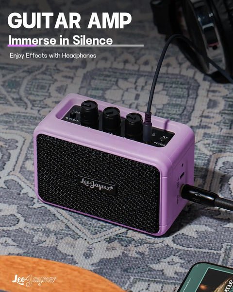 Compact 5W Guitar Amp for On the Go with Dual Speakers in Purple, showing headphone jack and control knobs on a patterned surface.