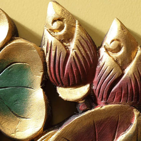 Close-up of handcrafted solid wood wall mount coat rack with gold and red floral designs for entryway organization.