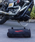 Ride Ready 48 Piece Motorcycle Tool Kit in a compact roll up next to a Harley Davidson V Twin bike on a driveway