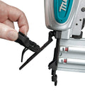 A hand adjusts the depth control on a Renewed 18 Gauge Pneumatic Brad Nailer For DIY Pros, showing narrow nose and aluminum body.