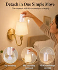 A woman easily detaches a magnetic bulb from the No Fuss Wall Sconces Set Of Two In Shiny Gold with charger access.
