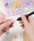 Using Badass Mini Micro Drill Bit Set With Tough Pin Vise to add beads in jewelry making, with colorful beads in background.