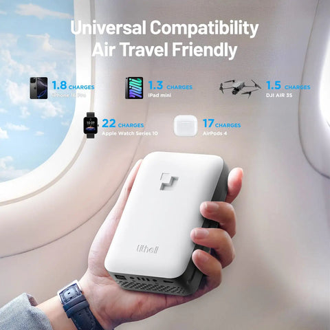 Hand holding portable charger labeled as universal compatibility and air travel friendly near airplane window.
