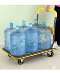 Heavy Duty Foldable Platform Cart With Self Balancing Frame And Glides Like Butter For Sweatless Warehouse Hauling And Driveway Moves Up To Six Hundred Sixty Pound Capacity loaded with six water jugs.
