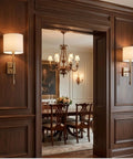 Fabric Shade Wall Sconce Vintage Brass Metal Lamp Bedside Indoor Lighting mounted on wood paneling next to a dining room.