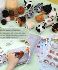 Needle Felting Kit For DIY Craft Lovers Dope 12 Piece Starter Set With Wool Instructions 12 Felting Needles Premium Felt Mat And Supplies To Create Cute Cat And Dog Figures For Home Decor, showing felt figures and crafting tools.