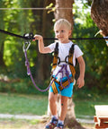 Child using Pulley Slider For Slack Line System With 440 Lbs Capacity in backyard obstacle course, wearing safety harness.