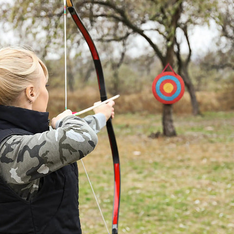 Archer aiming at Portable 20 Inch Round Straw Archery Target, 4 Inch Thick, Lightweight Handmade Solid Straw Target With Deep Red Finish