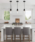 Slick Five Point Five Inch Seeded Glass Mini Pendant Light Featuring Badass Black Metal Hanging Fixtures for Kitchen Island and Dining Room above kitchen island.