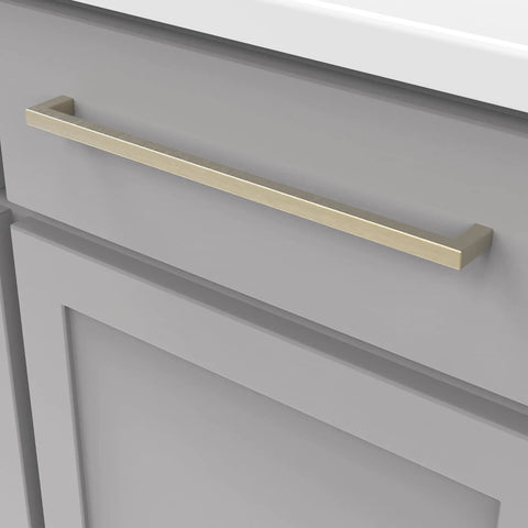 Solid Core Cabinet Pulls In Champagne Bronze, 12 Inch Center, Heavy Duty Luxury Hardware mounted on gray cabinet door.