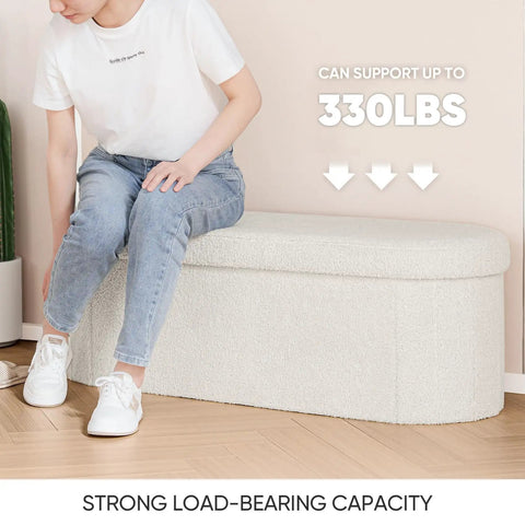 Person sitting on Go To Storage Ottoman With Cozy Sherpa Lining For Living Room Foldable Foot Rest Bench 43.3 Inch, 330 lbs capacity.