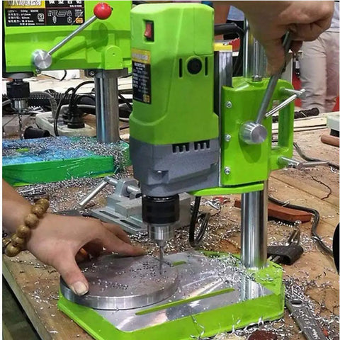 Beefy 710W Mini Drill Press with Cast Iron Base in action on a workbench, showing hands operating the drill on metal