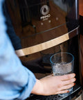 Person using Top Loading Water Dispenser With Hot And Cold Water, 5 Gallon Bottle Compatible, pouring water into glass