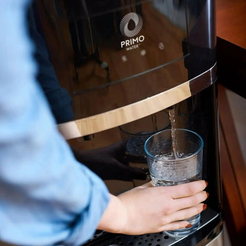 Person using Top Loading Water Dispenser With Hot And Cold Water, 5 Gallon Bottle Compatible, pouring water into glass