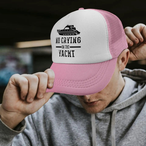 Pink Women's Breathable Sports Trucker Cap With Anti-Sweat Band worn by person holding brim, mesh back visible, outdoor setting