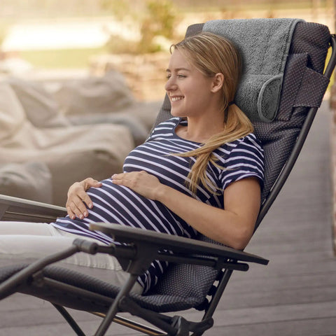 Woman relaxing on a chair with Cozy Recliner Pillow Neck Support Headrest Cushion For Travel And Home Office Relaxation Pain Relief.