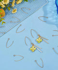 Golden V Shape Stainless Steel Earring Hooks, 50 Pcs Metal Ear Wires With Horizontal Loop For Jewelry Making DIY Earrings Findings displayed on a blue surface with decorative elements.