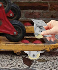 Heavy Duty 5 Inch Nylon Brake Caster Wheels With Rock Solid Stainless Steel Plate being held, showcasing its durable design and smooth wheels.