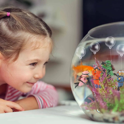 Child admiring Floating Diver Aquarium Decor 4 Pack, cute little diver toys in a fish tank, durable resin, adds playful ocean vibe
