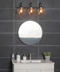 Lofty Chic Three Light Vanity Light In Dark Bronze With Clear Glass Shades And Antique Brass Accents over bathroom mirror