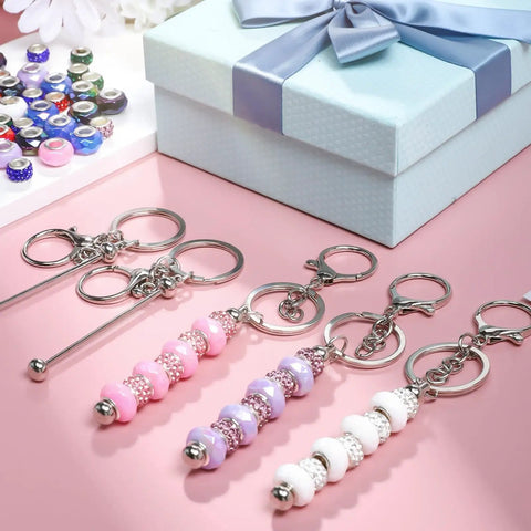 84Pcs Beadable Keychains Set With 12 Bendable Keychains, 36 Silicone Beads, And 36 Spacer Beads displayed on pink surface