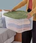 Person holding Heavy Duty 2 Pack 40 Quart Clear Plastic Storage Bins Stackable Totes with blankets inside.