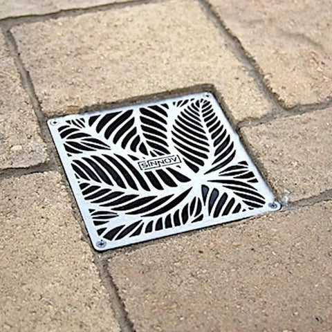 Pro Grade Outdoor 6 by 6 Paver Drain Grate for Driveways and Patios, stainless steel, installed in a brick patio, close-up view