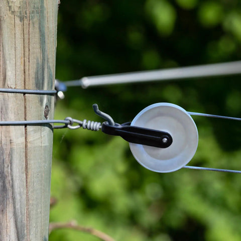 Two Pack Nylon Clothesline Pulleys For Outdoor Rope Drying System Smooth Tangle Free Pulley Kit With Durable Nylon And Metal Rollers Easy To Install Perfect For Indoor And Outdoor Clotheslines. White pulley on wooden post with clothesline