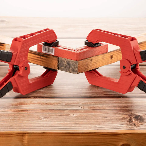 Two 9 Inch Heavy Duty Spring Clamps With Kickass Grip holding a wooden board and a red block for woodworking tasks.