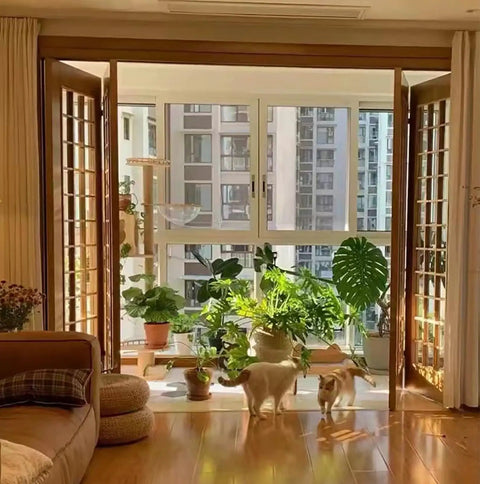 Sunlit living room with open bifold doors and indoor plants, showcasing Heavy Duty Bifold Closet Door Hardware Kit Fits 48 to 96 Inch Tracks.