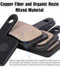 Close-up of mixed copper fiber and organic resin MTB brake pads, showing texture and material, four pairs stacked.