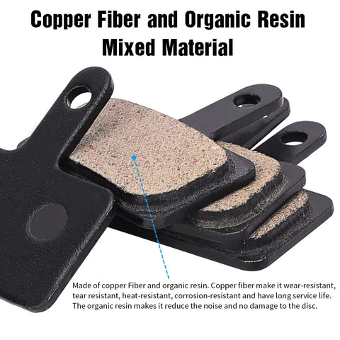 Close-up of mixed copper fiber and organic resin MTB brake pads, showing texture and material, four pairs stacked.