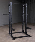 Tight Footprint Commercial Half Rack Package Featuring Olympic J Hooks Heavy Duty Spotter Bars And Weight Horns Beast Mode Strength Setup Built For Serious Deadlifts Squats Plus Daily Stretching Sessions In Matte Black, front view.